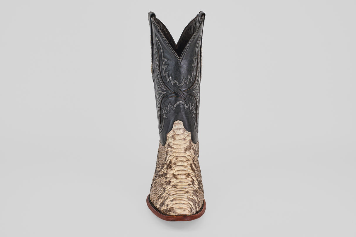The Tanner - Natural - Roper Toe cowboy boot features a natural tan python snakeskin lower section and a black leather upper with detailed stitching, shown upright against a plain light background.