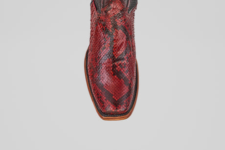 A close-up top view of the Tanner – Ruby – Narrow Square Toe, a red Python leather cowboy boot with a brown sole, set against a plain white background.