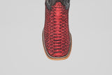 A close-up of the Tanner – Scarlet – Square Toe boot highlights its red python leather, black accents, and square light brown sole, capturing classic western style against a plain white background.