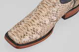 A close-up of the Tanner - Natural - Rodeo Toe boot shows its Python Natural snakeskin, visible scales, dark trim, and wooden sole—an ideal choice for a standout rodeo look.