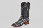 The Conor - Newspaper boot features a black, narrow square toe with a scale-like lower pattern reminiscent of fish leather, a smooth leather upper, pull straps, and a brown wooden heel, all showcased on a white background.