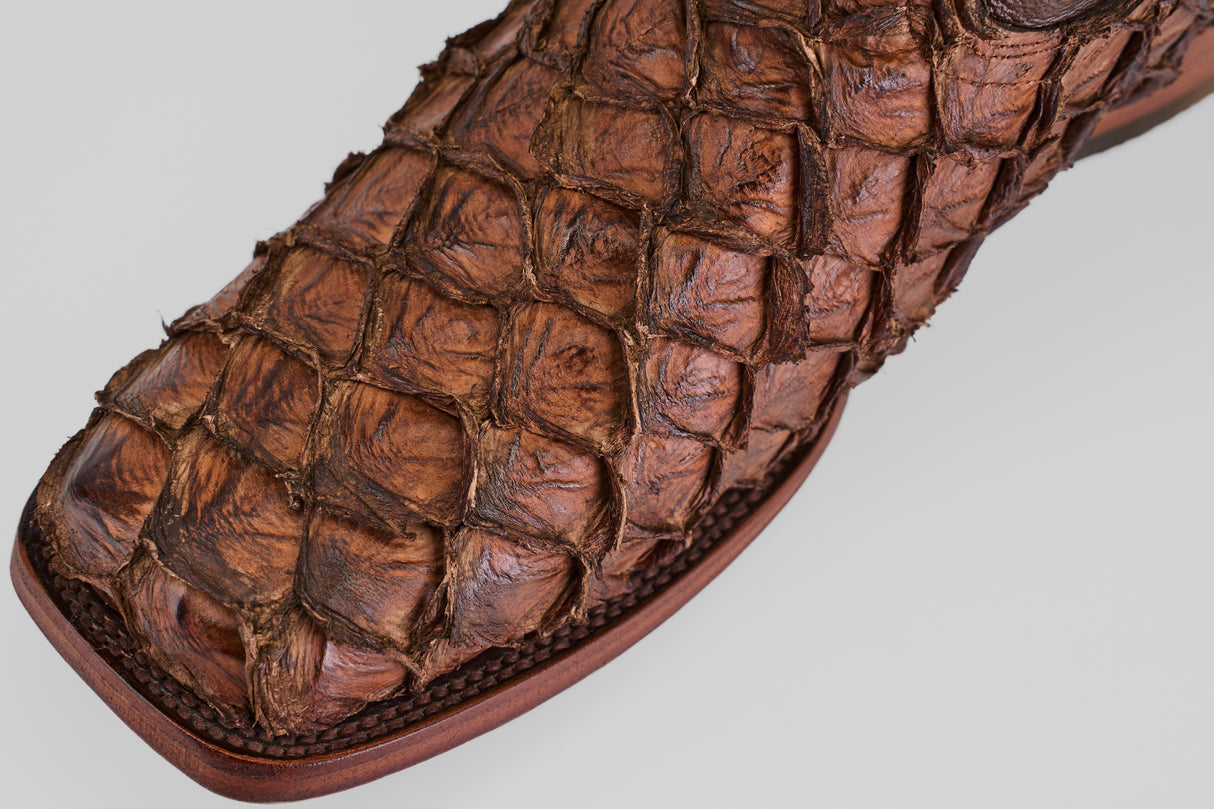 Close-up of the Conor - Brown - Rodeo Toe boot, featuring textured, scaly leather with a distinct pattern and expert craftsmanship on the square toe for bold western style.