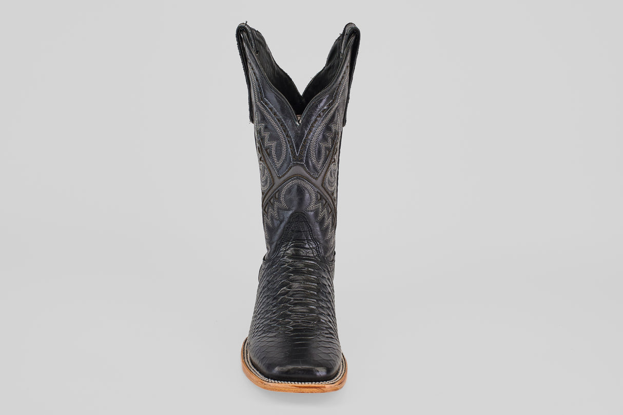 The Python Black - Embossed Leather - Square Toe (E425) cowboy boot is shown from the front, featuring detailed stitching and a textured pattern on black embossed leather against a plain light gray background.