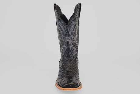 A single Ostrich Black - Embossed Leather - Square Toe (E424) cowboy boot with textured details and decorative stitching, shown from the front on a plain light gray background. Features a light brown sole and slightly pointed toe.
