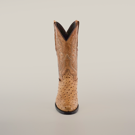 The Karoo Ostrich Print Orix - Round Toe cowboy boot, shown front view, features intricate stitching on the shaft. Its made from premium cowhide with a dark leather sole and has a V-shaped opening at the top, set against a plain white background.