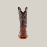 Front view of a single handmade boot, showcasing the detailed pattern on the shaft with brown leather and intricate stitching over a Karoo Ostrich Print Chocolate base. The Square Toe design is highlighted as it rests on a flat surface.