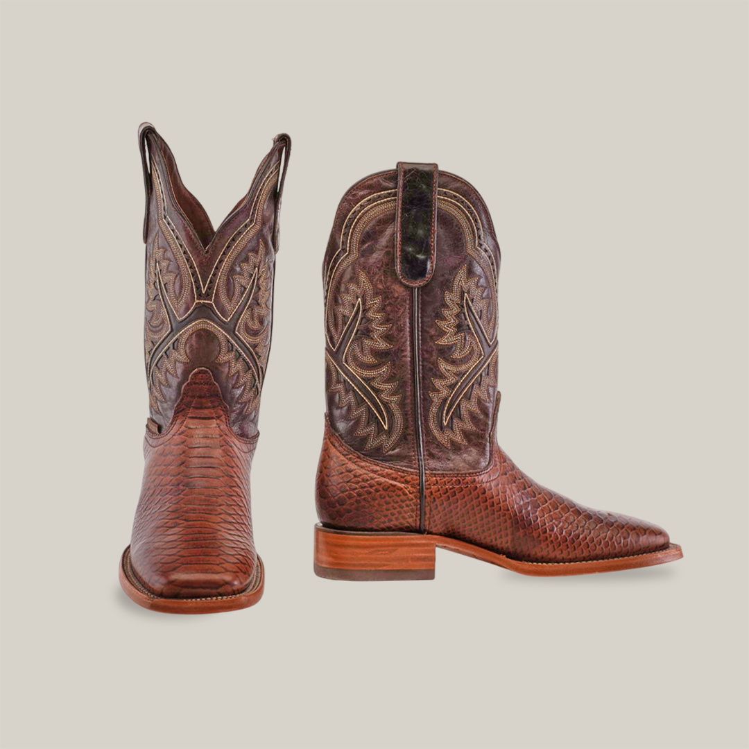 The Python Print Brown - Square Toe boots are shown against a plain white backdrop, featuring intricate stitching and a worn look. Crafted from premium cowhide leather, these cowboy boots display detailed upper patterns and have low stacked heels.