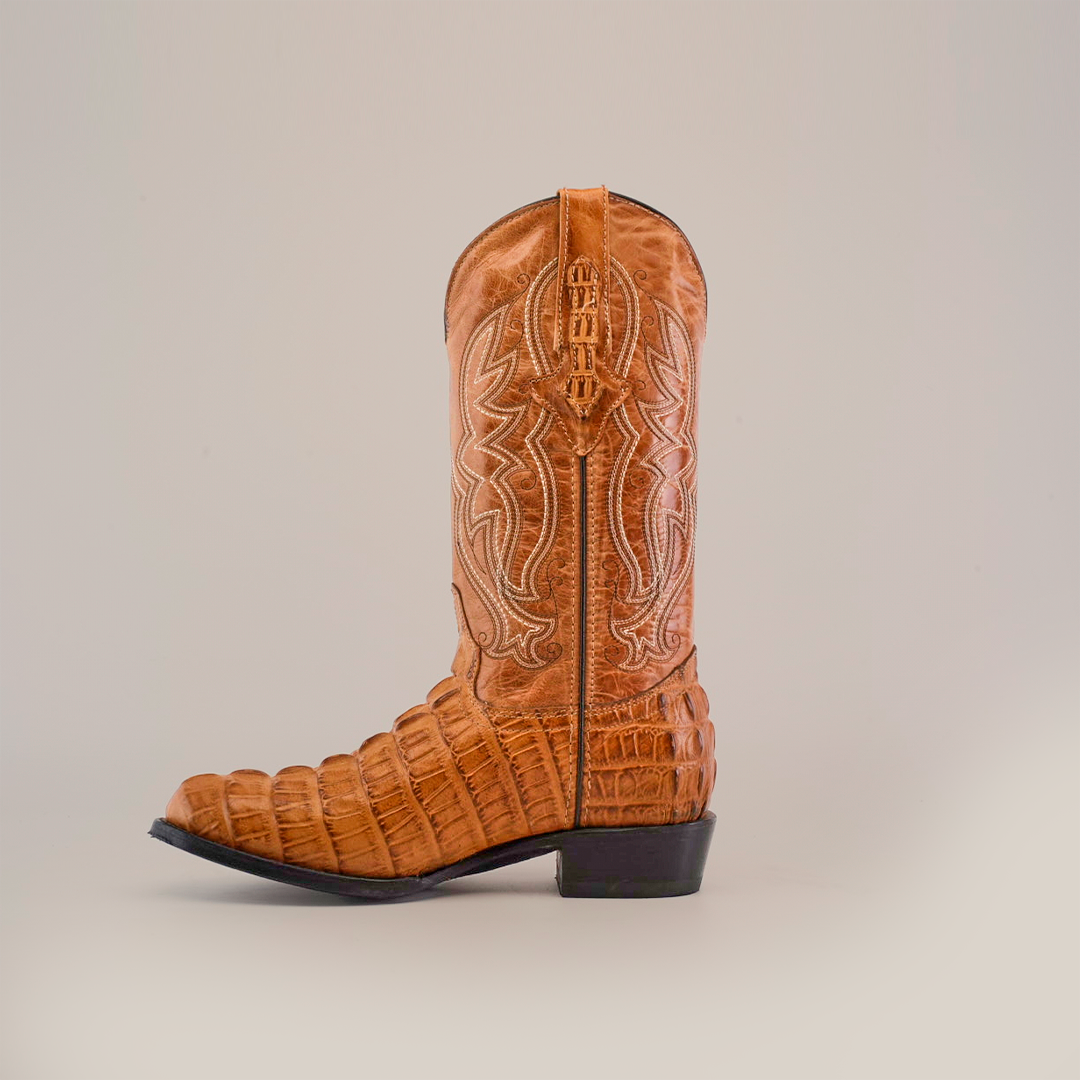 The brown Orix cowboy boot, with a crocodile tail print, is handcrafted from premium cowhide leather and features intricate white stitching, a slightly pointed toe, and a short heel.