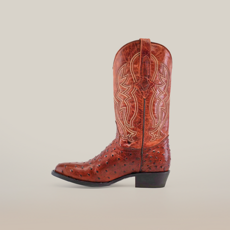 The Karoo Ostrich Print Cognac cowboy boot, in a round-toe design, features intricate stitching and decorative patterns. Crafted from premium materials with a medium heel and textured finish, it embodies the charm of handcrafted Western-style boots.