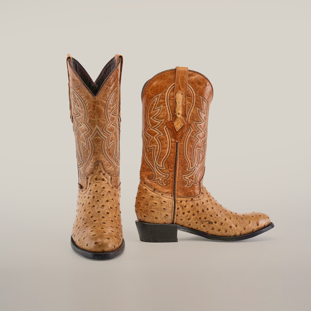 A pair of Karoo Ostrich Print Orix - Round Toe cowboy boots in tan leather features intricate stitching. One boot faces forward, the other to the side, showcasing the leather sole and pull tabs on a plain white background.