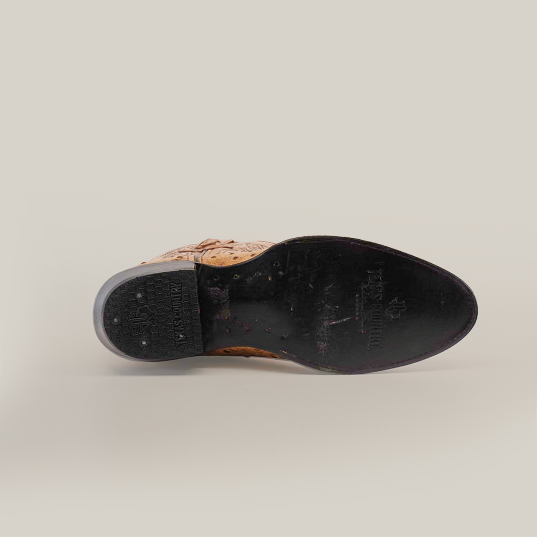 A single Karoo Ostrich Print Orix - Round Toe shoe, made of premium brown leather, is shown from the bottom with a black leather sole. Intricate designs and stitching enhance the heel and sole areas, showing some wear. The background is plain white.