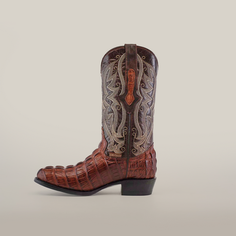 The Crocodile Tail Print Chocolate boot is crafted from premium cowhide with a glossy brown crocodile-patterned lower and intricately embroidered upper. It features a western-style heel, leather sole, and detailed stitching, all beautifully showcased against a plain white background.