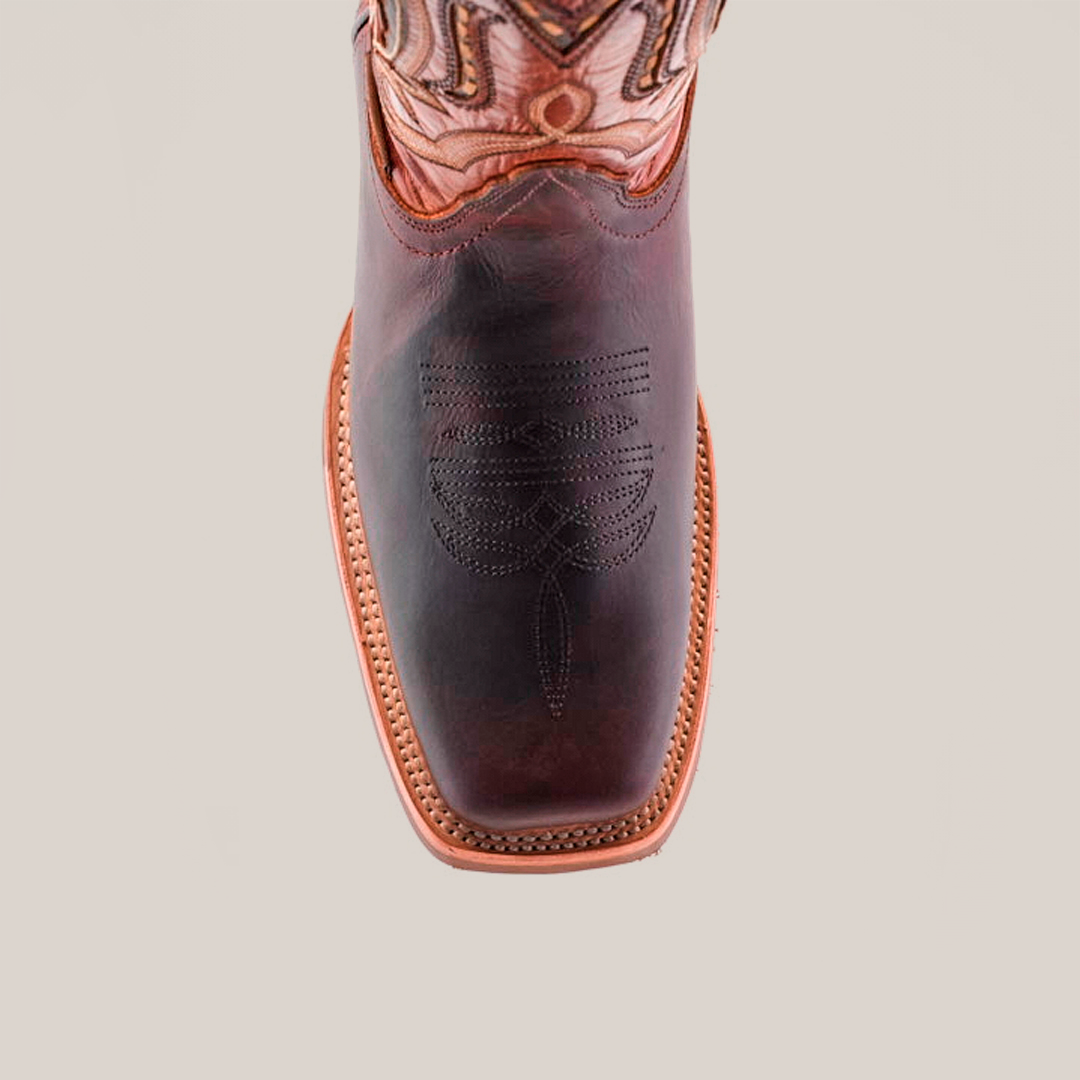 A top view of Azkar Moka boots reveals intricate stitching on the dark cowhide leather toe and an ornate design on the shaft. These boots, crafted from premium materials, feature a light brown slip-resistant sole with a visible seam around the edge.