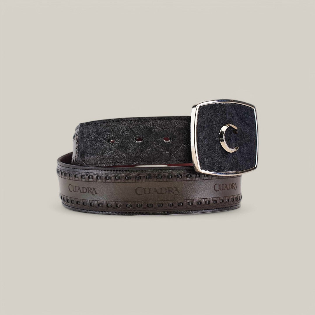 The product is a Black Elephant Laser & Woven Belt - BC313, featuring a unique crescent-shaped silver buckle and Cuadra written along its black leather design. The backdrop is plain and neutral.