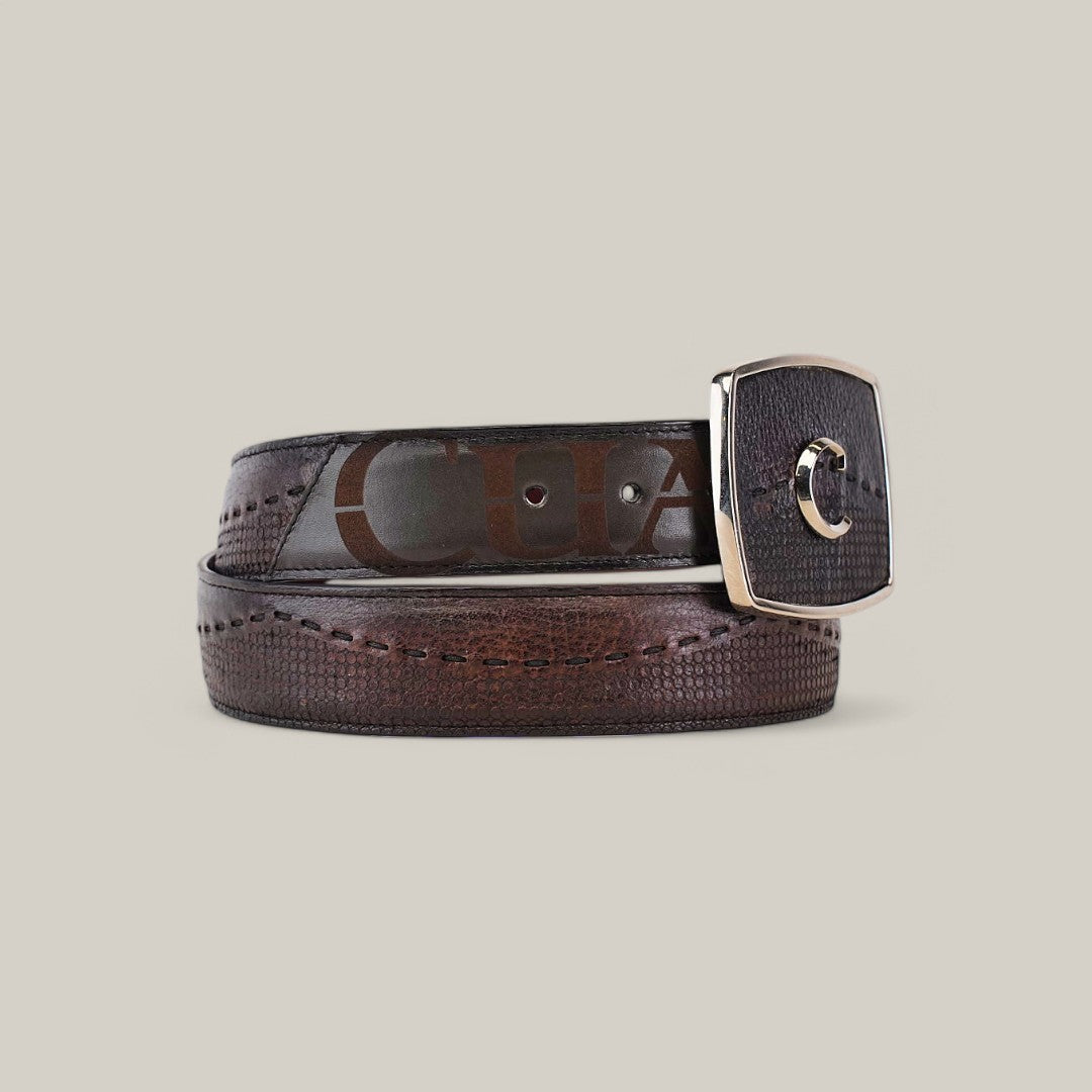 The Firenze Grey Shadow Deer Laser & Woven Belt - BC237 is a luxurious accessory, boasting a textured pattern with visible stitching and a silver-tone buckle. Coiled neatly on a plain background, its elegance is highlighted by the partial lettering through the transparent section.