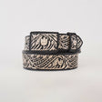 The Artisanal Handmade Silver Belt Flowers Deluxe is a luxurious black belt, intricately designed with silver thread embroidery featuring floral and leafy patterns. Handcrafted and showcased rolled up on a plain white background, it highlights its decorative beauty along the length.