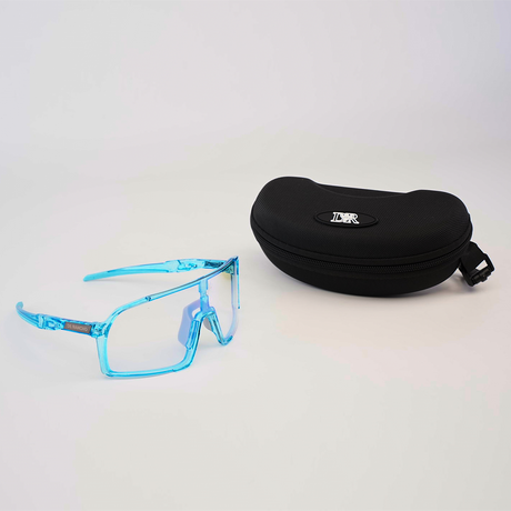 The DR Sport Sunglasses Blueberry, with a trendy angular translucent blue design and UV protection, are displayed beside a black zippered case with a brand logo on top, set on a light surface.