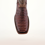 Close-up of a single Exotic Caiman Hornback boot in rich brown, showcasing luxurious hornback details with a Rodeo toe against a neutral background.