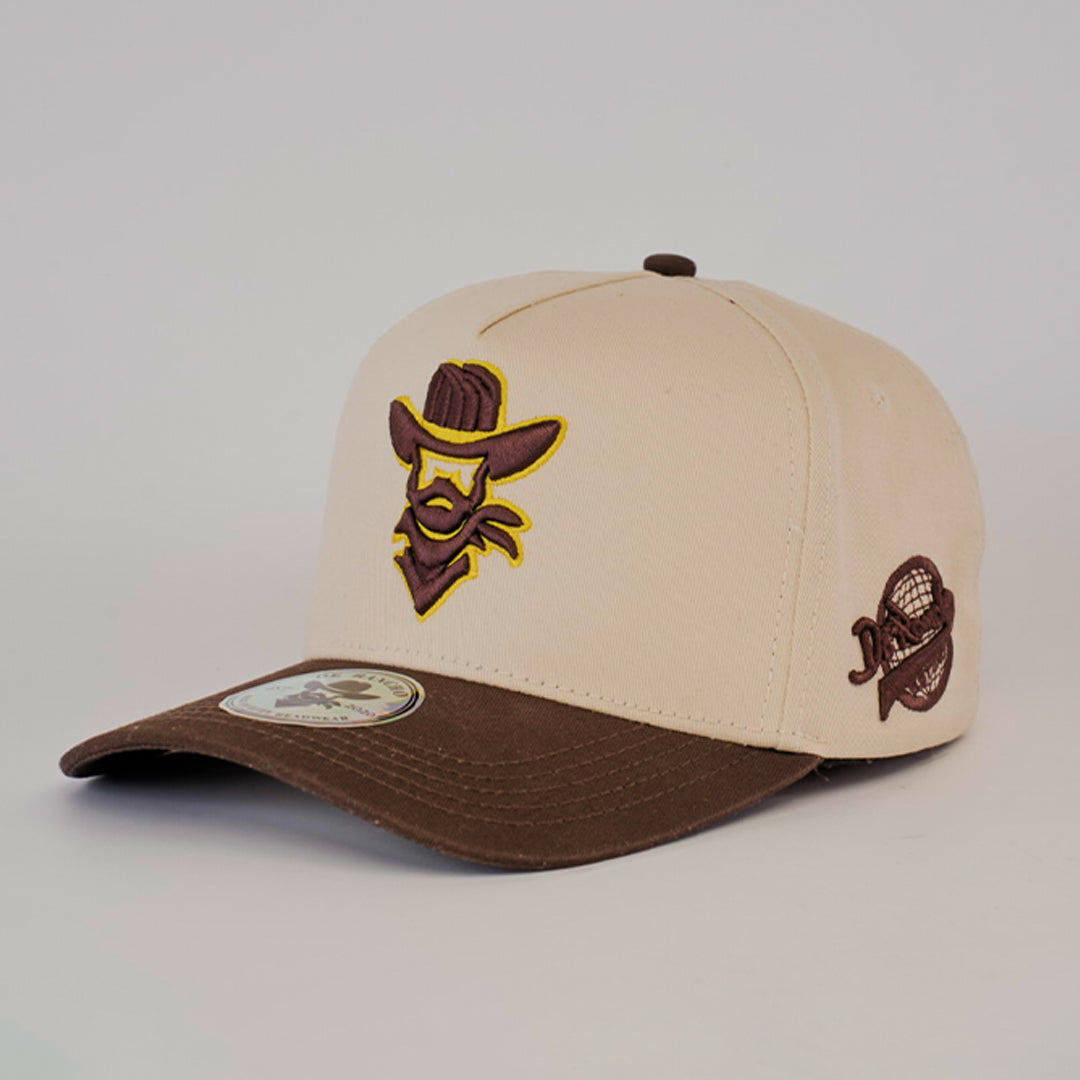 The De Rancho Cap Camel merges ranch culture and modern style with its beige/brown color, embroidered cowboy logo on the front, baseball emblem on the side, and a curved brim. This stylish accessory pays homage to Western heritage.