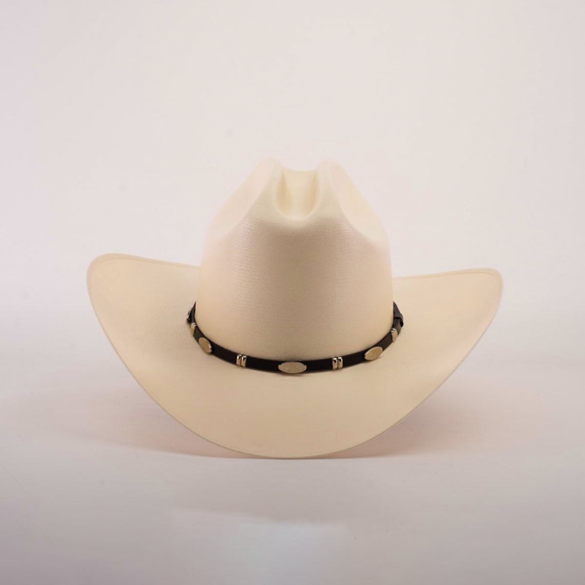 The 5000x Sinaloa Straw Hat, in cream, exudes elegance with its wide brim and a black hatband adorned with oval decorative elements, highlighting fine craftsmanship against a plain white background.