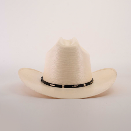 The 500X Dos Carnales Straw Hat is cream-colored with a wide brim and slightly pinched crown, highlighting its quality and durability. It has a black band adorned with decorative gold elements on a plain white background.