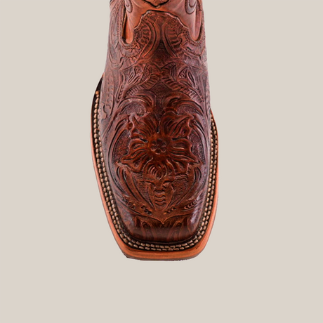 Top view of the Handtooled Leave Brown boot, expertly handcrafted from premium cowhide. With floral and leaf engravings on the toe, this rodeo-toed beauty with a slip-resistant sole pops against a plain background with its rich leather finish.