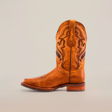 The Wild Mustard boot features decorative stitching on premium cowhide leather with a slightly worn texture and a wooden heel. This single brown cowboy boot is set against a plain white background.