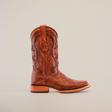 The Handtooled Leave Cogñac cowboy boot displays intricate floral and swirl engravings on premium brown cowhide leather. It features a low heel, rodeo toe, slip-resistant sole, and a side pull-strap, all showcased against a plain white background.