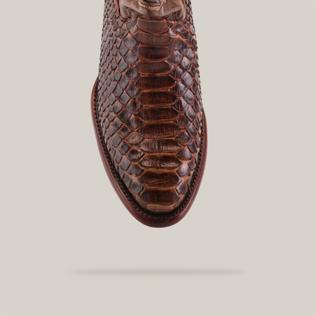 Close-up of the Exotic Python Brown Round Toe boot with a textured, snake scale-like pattern, viewed from above on a plain background. This boot showcases intricate edge stitching, capturing genuine Western footwear essence.