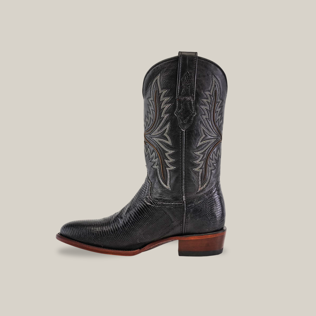 Set against a beige background, the Exotic Lizard - Black - Round Toe features intricate shaft stitching, round toe design, and a brown heel. Handcrafted from genuine lizard leather by skilled artisans, it combines elegance with tradition.