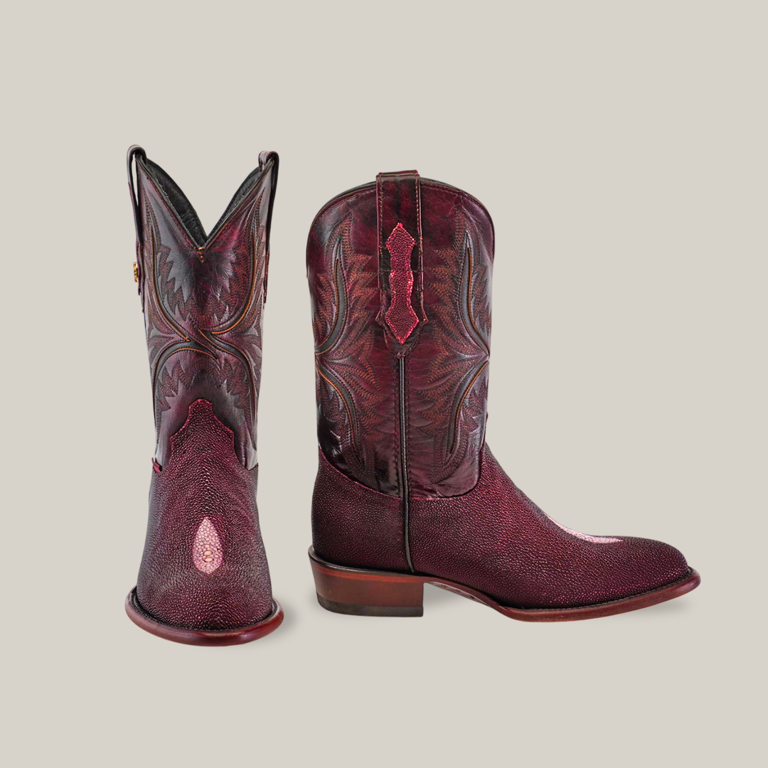 A pair of Exotic Stingray - Wine cowboy boots features intricate embroidery and leather detailing with luxurious stingray leather. The left boot is slightly forward and to the side of the right, showcasing its square toe design from various angles against a neutral beige background.