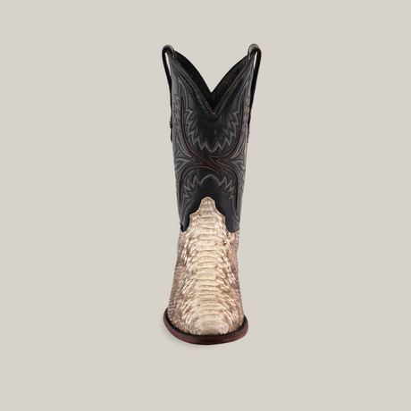 The Exotic Python - Natural - Round Toe boot, crafted from luxurious python, features a tan, textured lower similar to real reptile skin and a dark brown upper with detailed stitching. This handcrafted piece is set against a simple light beige background.