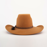 The 6X Brazil Fawn is a brown cowboy hat featuring a flat brim and decorative braided band with a small tassel on the right side, crafted from premium leather, and displayed against a white background.