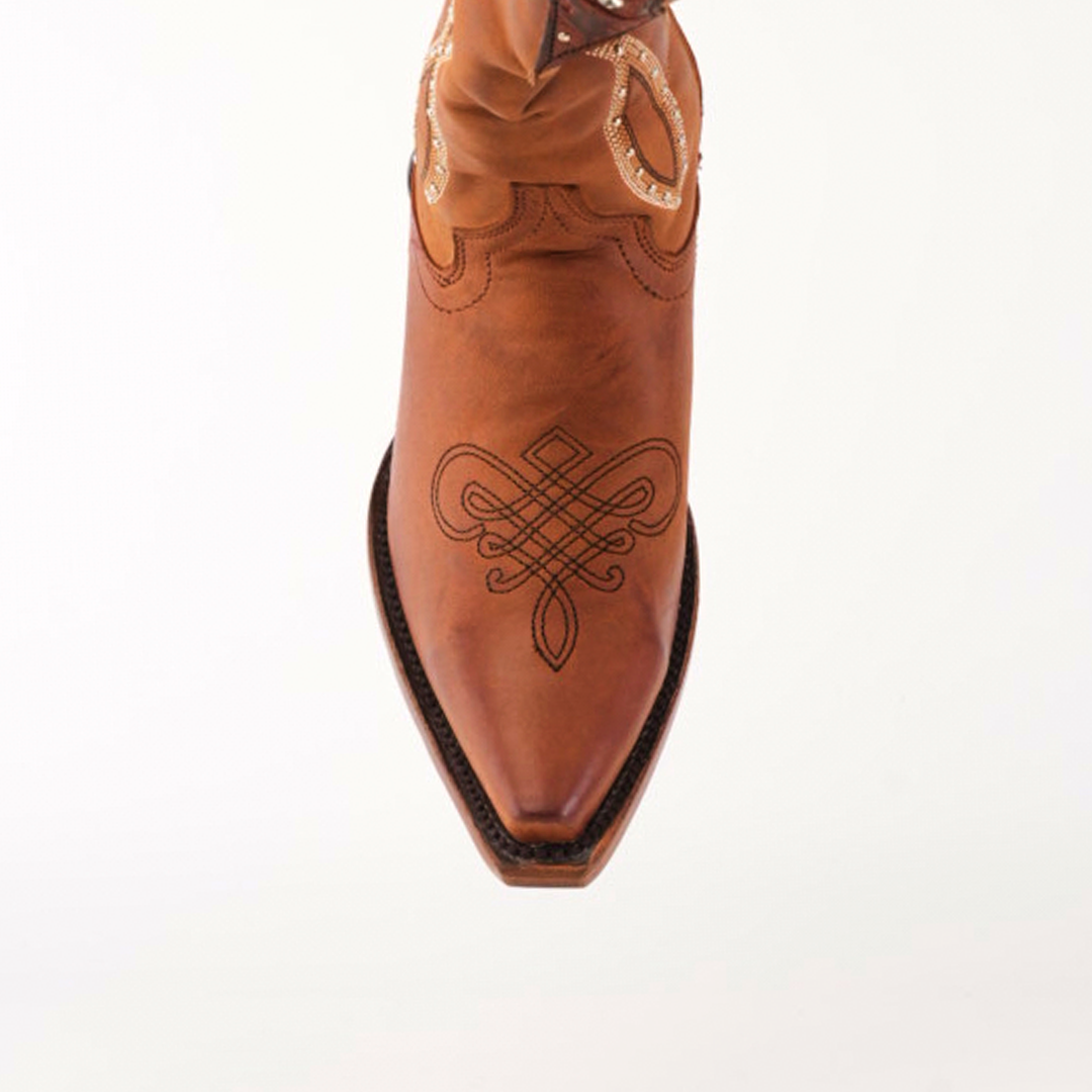 Close-up of the Miriam Brick Tall Shaft Snip Toe cowboy boot, crafted from premium materials, featuring intricate embroidery on the snip toe and dark stitching on the sole. The background is plain white.