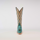 The Premier Turquoise Handtooled Flowers boot, in teal and tan, crafted from premium quality leather with intricate patterns and stitching, stands upright against a plain white background.