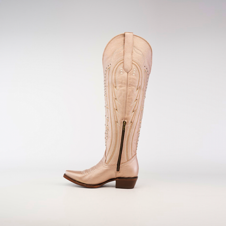 A single tall beige cowboy boot with decorative stitching and a side zipper is showcased against a white backdrop, echoing the iconic Sara Metalic Florentine - Tall Shaft - Snip Toe design.