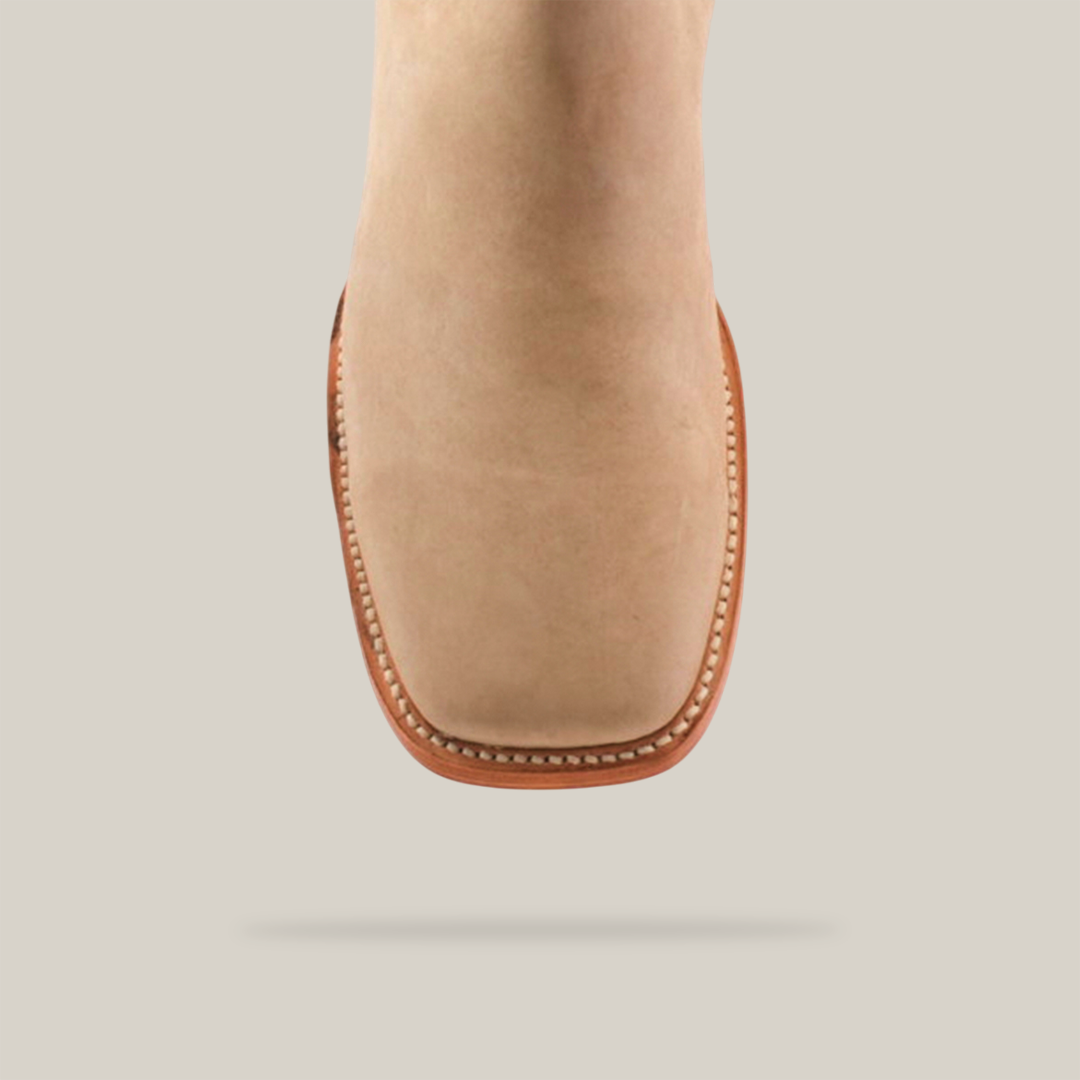 Close-up of the Prime Suede Pearl Square Toe, a beige prosthetic foot with a square toe and light brown border like handcrafted boots, set against a plain white background.