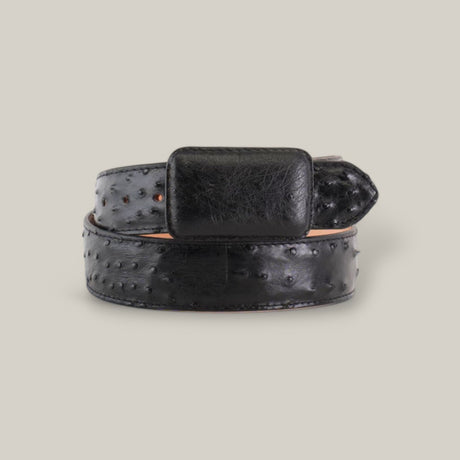 A black Exotic Full Quilt Ostrich belt with a large, flat buckle is set against a light gray background. The handcrafted beauty of its textured surface and raised dots suggests ostrich leather.