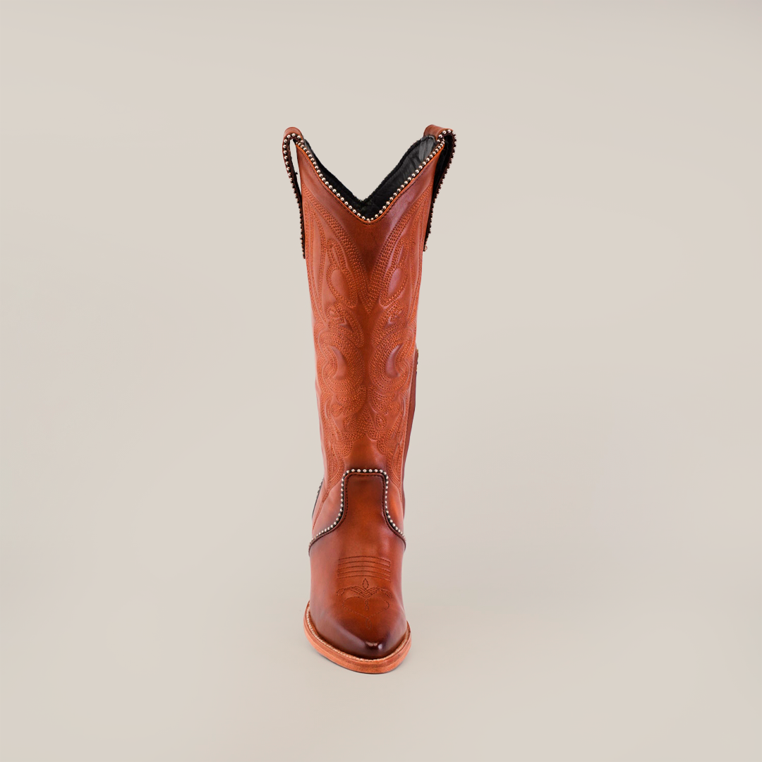 A single Linda Tall Shaft Tan - J Toe cowboy boot from the Platinum Collection stands upright against a plain background. Crafted from premium leather, it features intricate stitching, a slightly pointed toe, and decorative trim along its tall shaft.