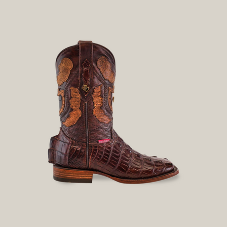 The Exotic American Alligator Hornback - Brown - Square Toe boot showcases exceptional craftsmanship with intricate leather patterns and textured detailing. It features a square toe, wooden heel, and ornate stitching on the decorative shaft, seamlessly blending smooth and patterned surfaces.