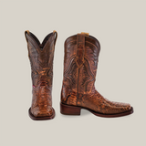 The Exotic Python - Brown - Rodeo Toe boots are crafted from python leather, featuring intricate patterns and texture. One boot stands upright against a plain background, while the other is tilted to showcase its side profile.