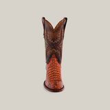 Front view of the Exotic Caiman Hornback - Brandy - Round Toe boot, made with genuine caiman leather. It features intricate brown and reddish-brown patterns, textured toe detail, and a decorative upper design, epitomizing western style against a plain light background.