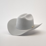 The 6X Real Platinum by Larry Mahan is a light gray fur felt Western hat featuring a wide brim, crown crease, and a subtle decorative band with a small buckle, set against a plain white background.