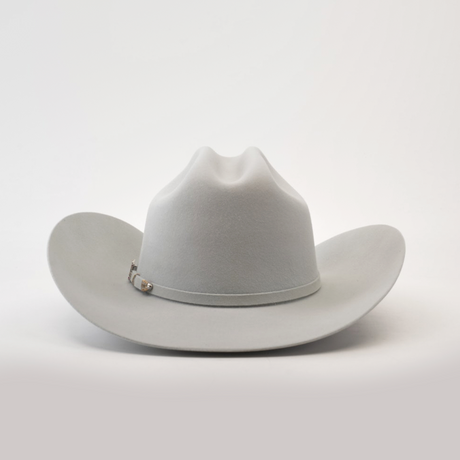 The 100X Independecia Platinum is a light grey cowboy hat from the Larry Mahan collection, featuring a wide brim and a stylish silver band, set on a smooth, neutral background.