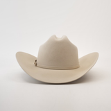 The Larry Mahan 100X Independencia Belly is a beige cowboy hat with a wide brim, dented crown, and a subtle decorative band. Crafted from premium full beaver fur, this luxury western headwear rests on a plain white background.