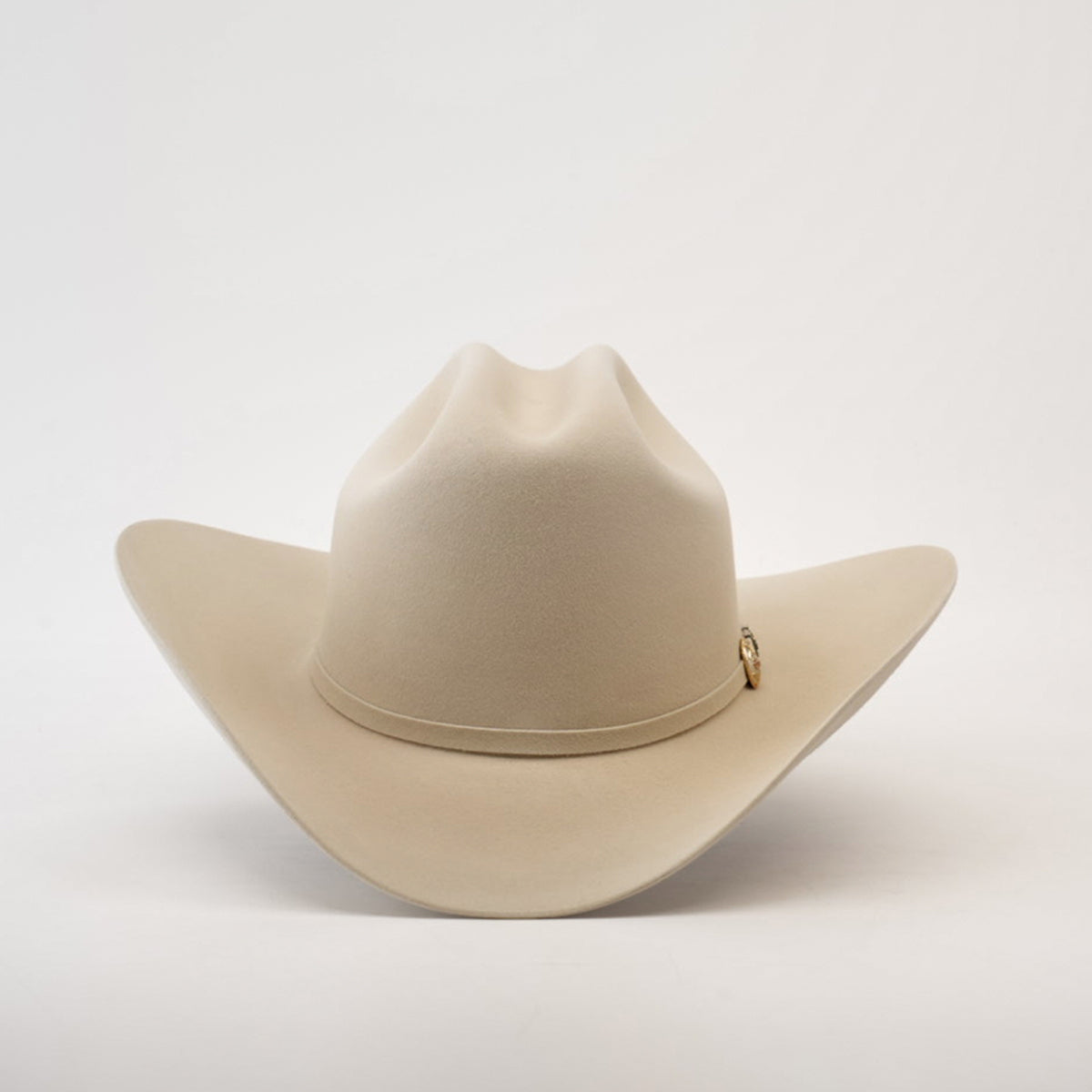 The 500X Superior Belly is a premium beige cowboy hat made from 100% belly beaver fur, featuring a wide brim and subtle top crease. Elegantly set against a plain white background, it boasts a small decorative emblem—truly exceptional Western headwear.