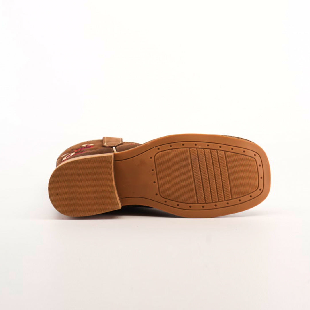 The image presents the bottom view of the Mia Copper Suede - Square Toe shoe in brown, highlighting its grooved sole on a white background. The sole has a textured pattern, and the upper section displays embroidery reflecting premium leather craftsmanship.