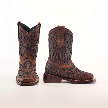 The Taurine Matte Chocolate Square Toe boots highlight premium leather craftsmanship with intricate brown leather patterns. The left boot is front-facing, the right side-facing, radiating western elegance against a plain white backdrop.