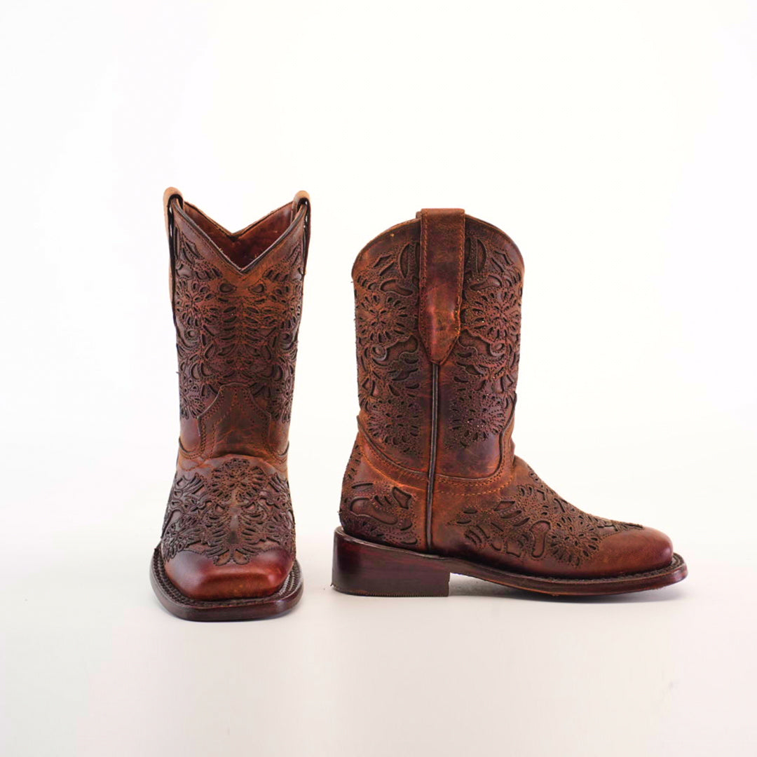 The Yennis Brick Square Toe boots, crafted from premium leather, are shown against a white background. These brown girls cowboy boots showcase intricate floral engravings, sturdy heels, and side pull tabs for easy wear.