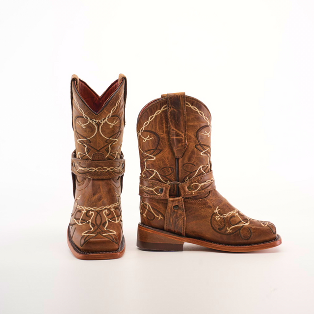 The Graffiti Yellow - Rodeo Toe are genuine leather cowboy boots with decorative stitching and a worn texture. Pictured on a white background, one boot stands upright while the other lies flat, ideal for adventurous young cowgirls.